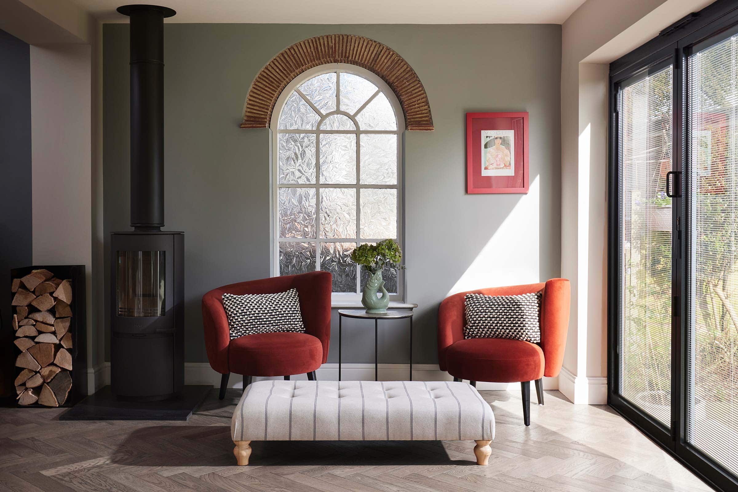 herringbone dark wood floors in a living room with modern furnishings and a large window