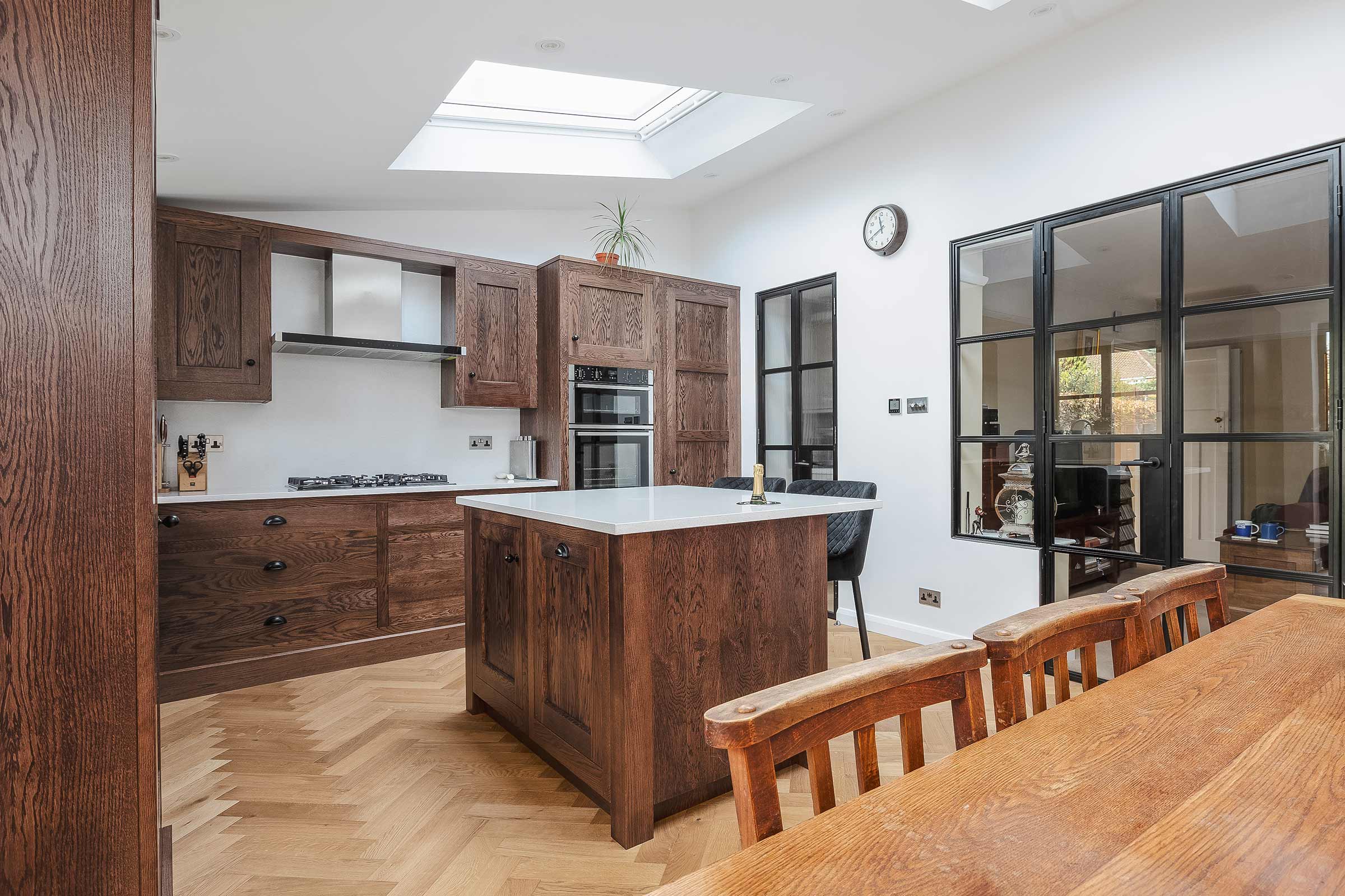 modern kitchen with herringbone wood floors and wooden cupboards